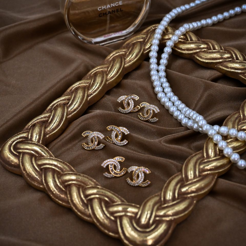 chanel style no 5 earrings in gold. adorned with cubic zirconia.