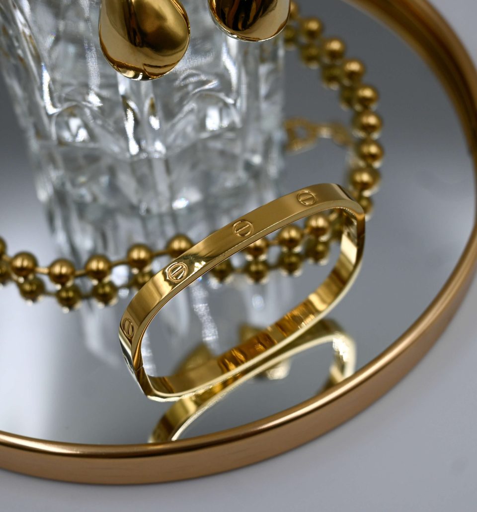square gold handcuff in stainless steel with 18K gold plating and mirror effect. care instructions for steel jewelry included.