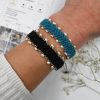 Handmade bohemian black macramé bracelet with freshwater pearls and herringbone braid. Crafted in Greece using eco-friendly, sustainable materials, symbolizing good luck and success.
