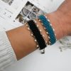 Handmade bohemian black macramé bracelet with freshwater pearls and herringbone braid. Crafted in Greece using eco-friendly, sustainable materials, symbolizing good luck and success.