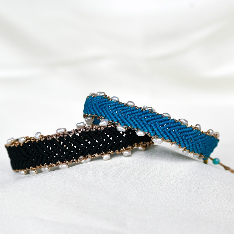 Handmade bohemian black macramé bracelet with freshwater pearls and herringbone braid. Crafted in Greece using eco-friendly, sustainable materials, symbolizing good luck and success.