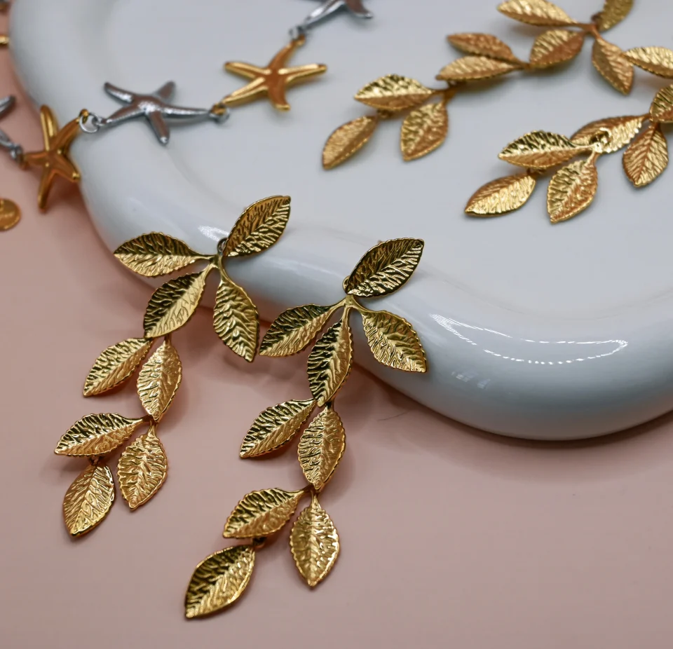 Gold dangle earrings featuring carved olive leaf designs, made of 18K gold-plated stainless steel with hypoallergenic stud clasp, perfect for bridal and weddings wear.