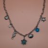 Starfish Silver Steel Charm Necklace with silver-plated steel chain and hanging charms including steel seashells, turtle, seahorse, white magnesite chips and a turquoise star. Water-resistant must-have summer jewelry for women.