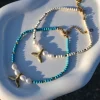 Summer steel mermaid tail pearl anklet with turquoise howlite stones. Featuring a gold plated steel chain that fluctuates, freshwater pearls and a central gold steel charm with mermaid tail. Water-resistant summer jewelry for every woman.