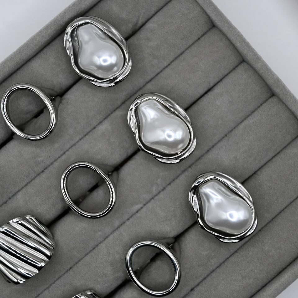 vera baroque pearl ring in stainless steel with silver plating and a lustrous baroque pearl, on jewelry display.