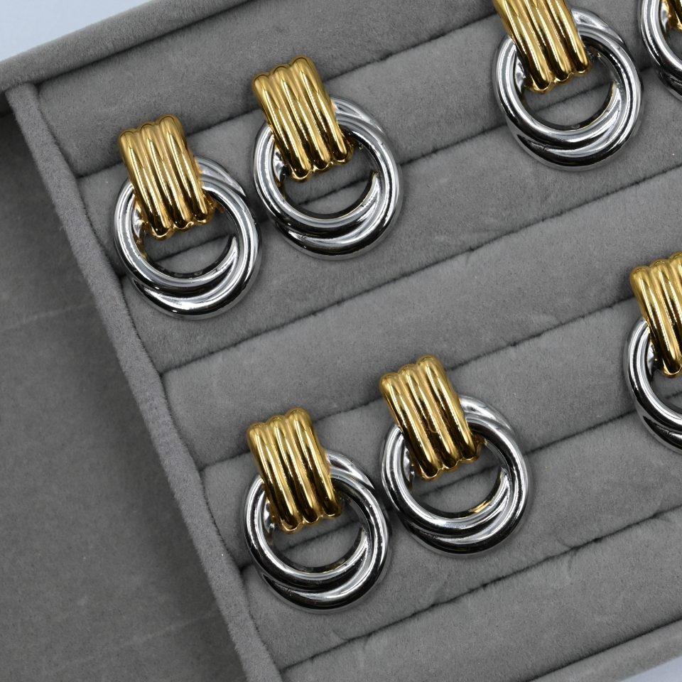The Eterna Duo Glossy Earrings are a must-have silver and gold jewelry piece, going viral on TikTok and Instagram. Made from durable stainless steel, these earrings add a modern touch to any outfit