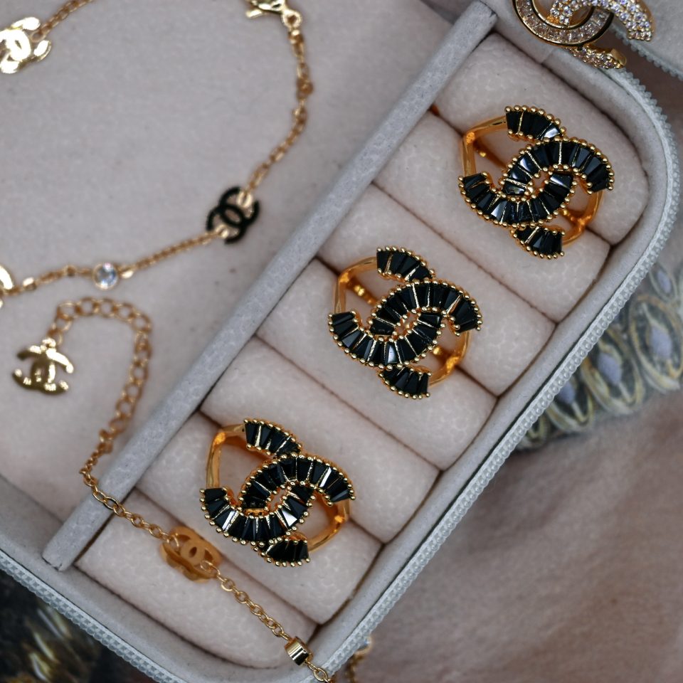 a chanel-isnpired adjustable ring made of metal alloy with high-quality gold plating and black crystal adornments.