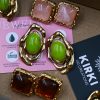 Y2K-inspired earrings made of durable stainless steel with 18-karat gold plating, featuring an irregular frame and light green resin stones.