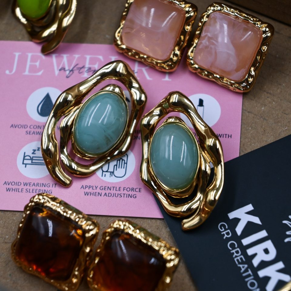 Y2K-inspired earrings made of durable stainless steel with 18-karat gold plating, featuring an irregular frame and turquoise resin stones.