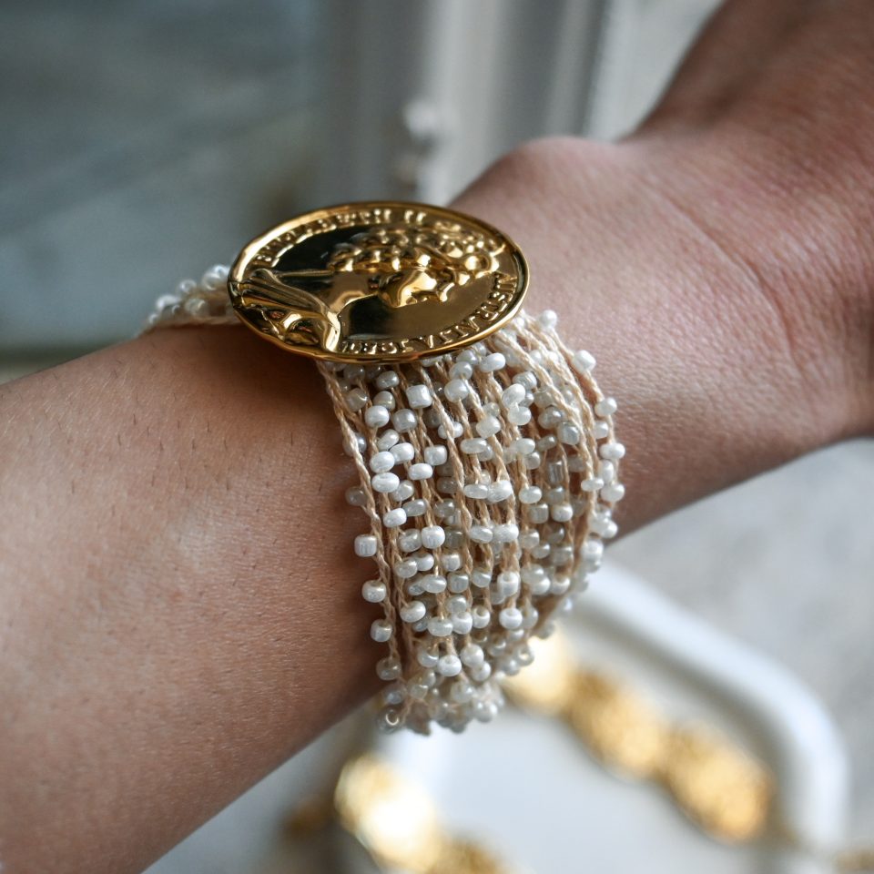 Gold coin beaded bracelet made of 18-karat gold-plated stainless steel, with silk thread and white beads. A boho-chic summer bracelet with personality and a unique character.