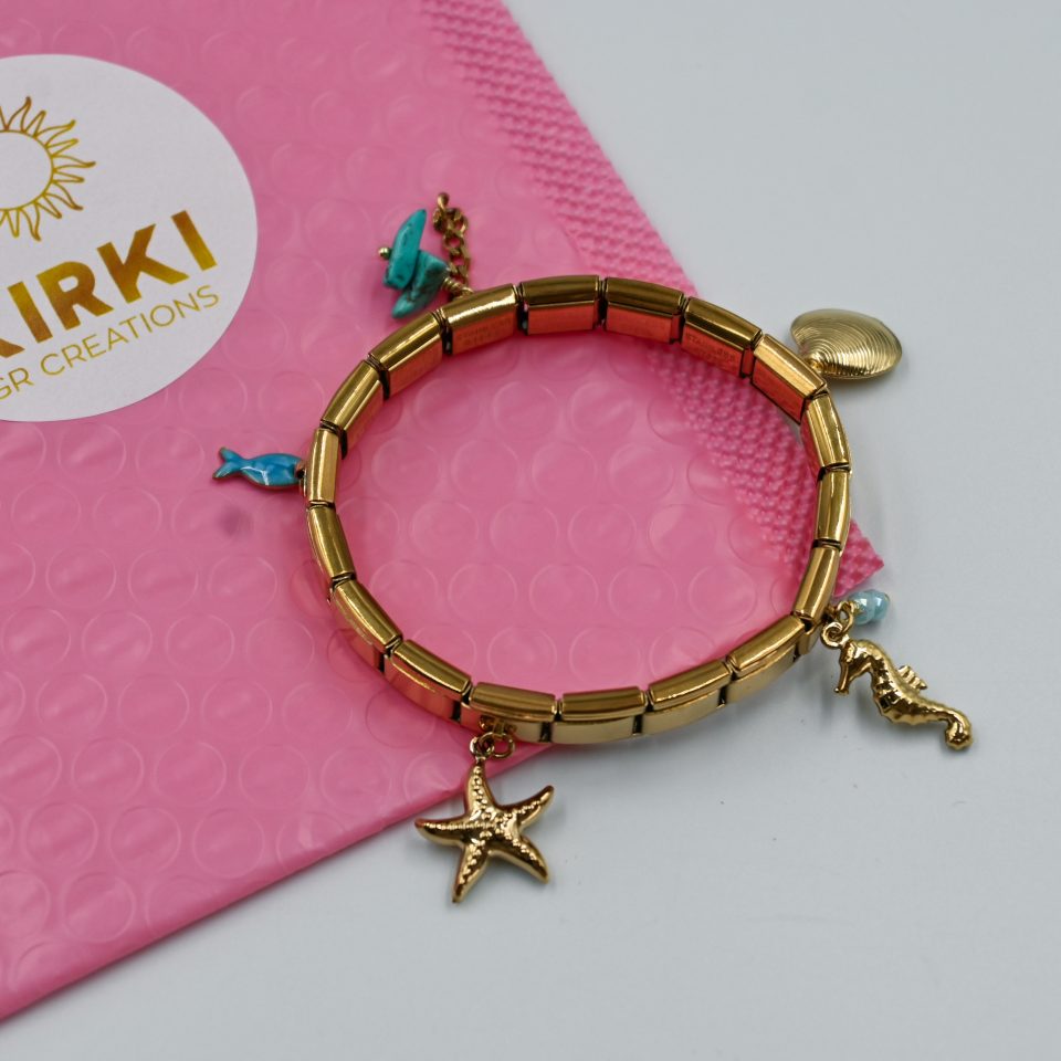 Amalfi Italian charm bracelet with sea-inspired charms (starfish, seahorse, seashell, blue fish) and turquoise chips. Elastic and perfect for summer styling.