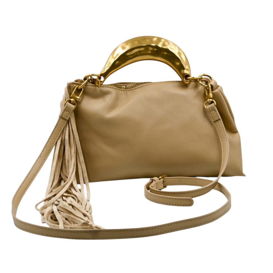 Gloria sand handbag, crafted from high-quality synthetic leather with a smooth texture. It features a statement metal handle in a gold shade with a hammered finish. It includes decorative suede tassels and a detachable leather strap.