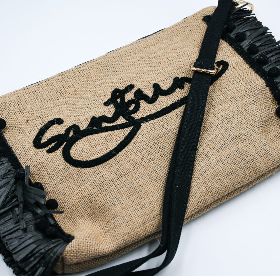 Black raffia beach clutch with detachable shoulder strap and spacious interior.