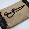 Natural raffia summer clutch with black tassels, zipper closure, and Santorini embroidery.