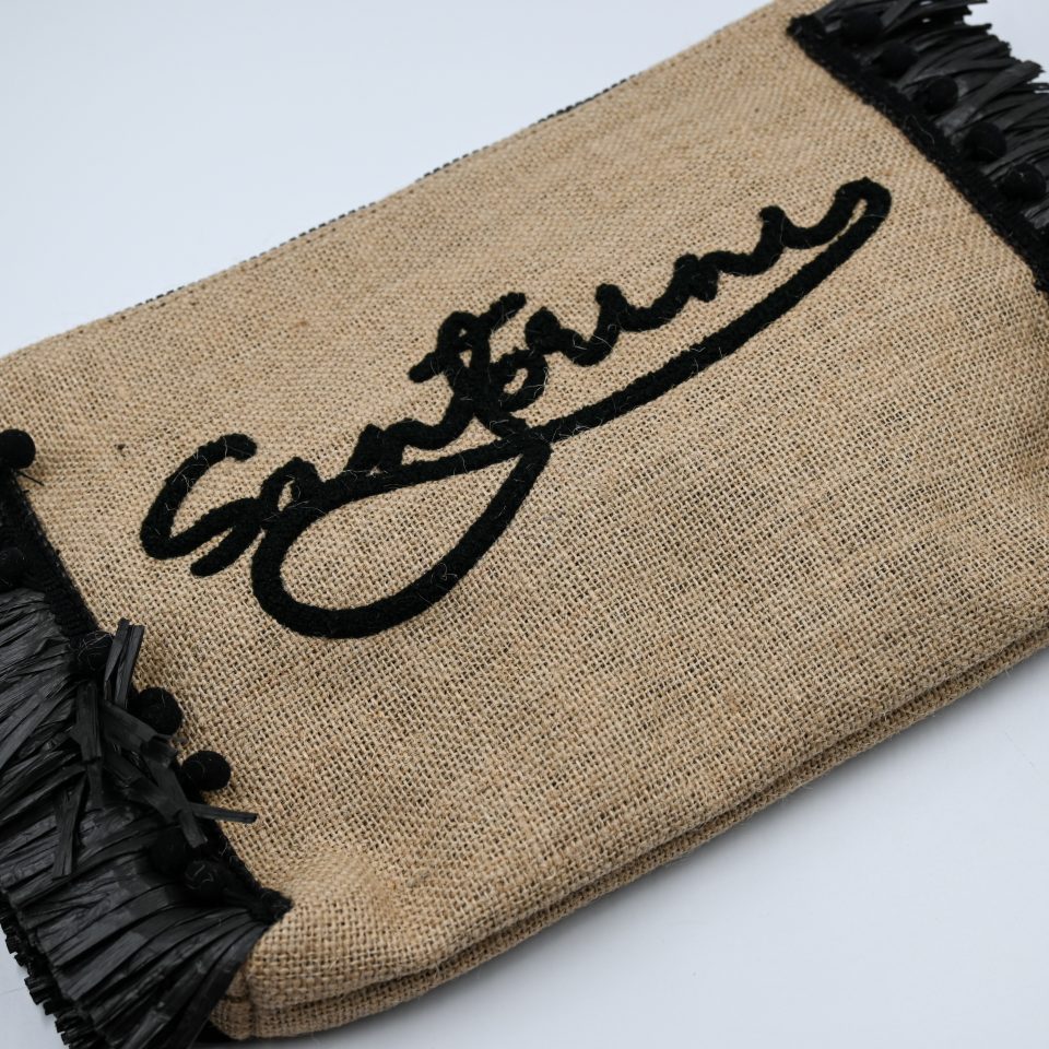 Natural raffia summer clutch with black tassels, zipper closure, and Santorini embroidery.