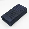 Kallisti Midnight Clutch Bag made of shimmering dark blue fabric with elegant front design, detachable silver chain, magnetic closure, dark blue lining, and interior pocket.