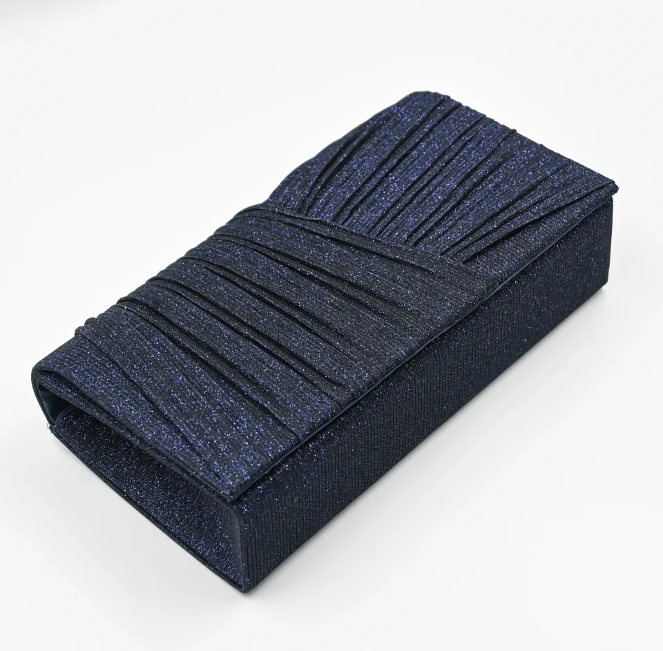 Kallisti Midnight Clutch Bag made of shimmering dark blue fabric with elegant front design, detachable silver chain, magnetic closure, dark blue lining, and interior pocket.