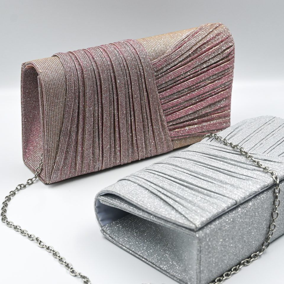 Kallisti Sparkling Pink Clutch Bag made of shimmering pink fabric with elegant front design, detachable silver chain, magnetic closure, pink lining, and interior pocket.